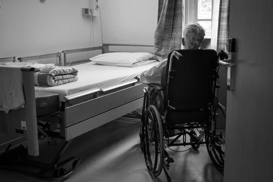 A person seated in a wheelchair in a bright, quiet room